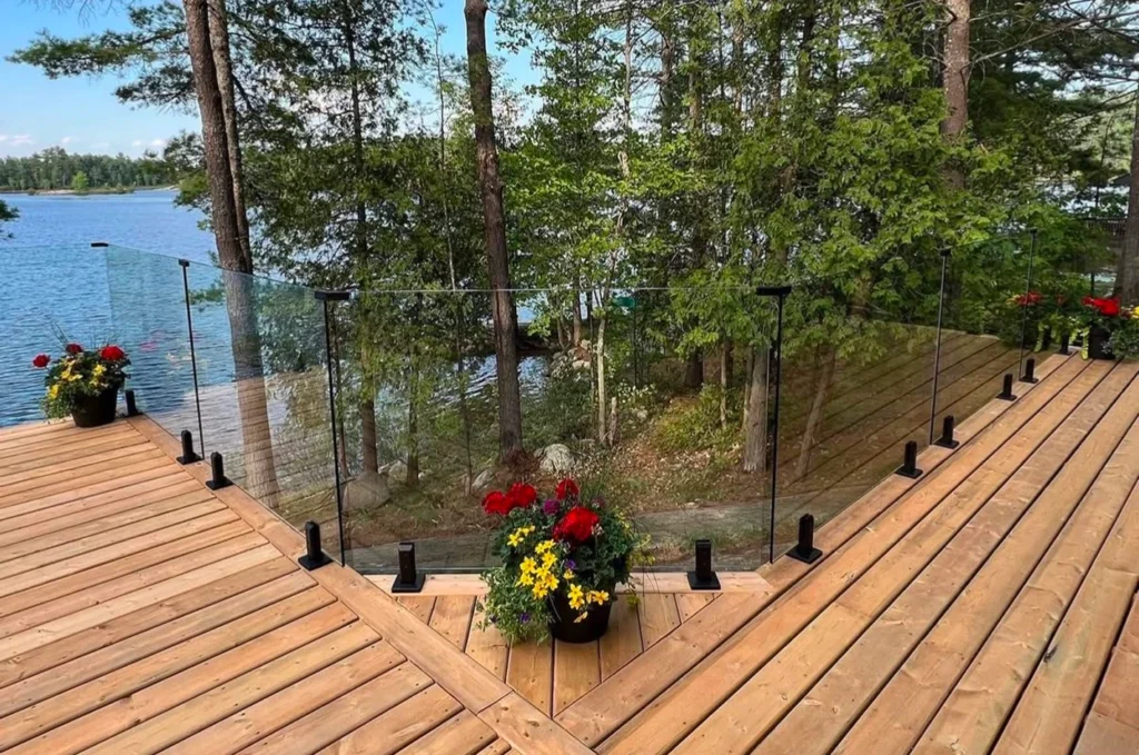 Waterfront deck and stairs featuring fully covered custom glass railing with unobstructed views