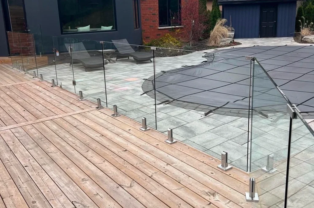Close-up of new frameless glass railing on backyard deck of modern home