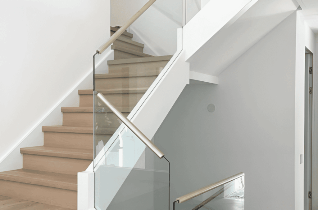 Minimalist interior balcony with frameless glass railing, reflecting modern glass railing design trends