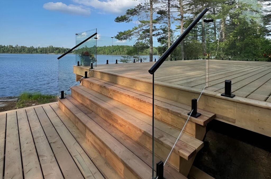 Outdoor glass railing on a cedar deck overlooking Puget Sound blending clear panels with natural wood and water views