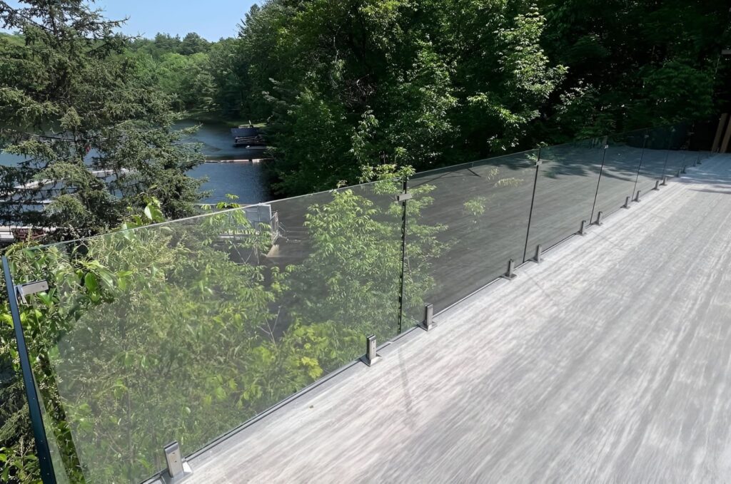 Glass railing installed on an outdoor deck with forest views, showcasing minimalist Puget Sound exterior design