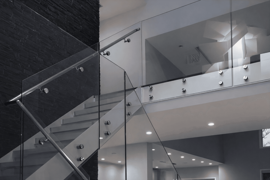 interior featuring modern glass railing systems paired with gray stairs for a balanced, elegant architectural style