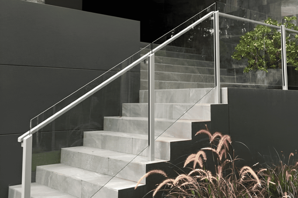 Modern outdoor staircase view with handrail glass railings and minimalist concrete steps