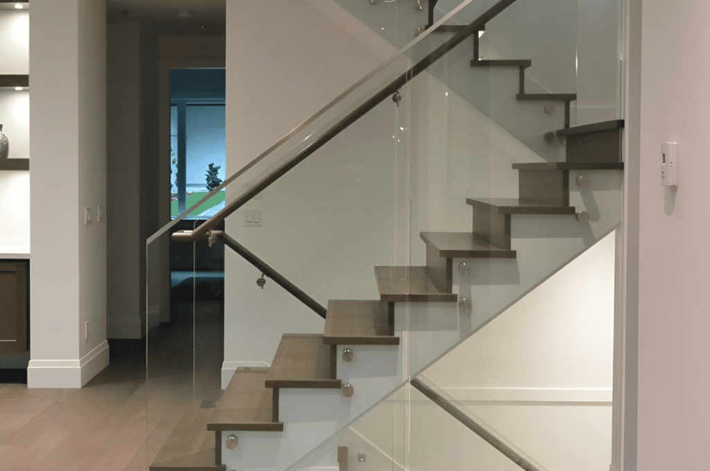 Interior floating stairs featuring wood treads and handrail glass railings for a clean, open look