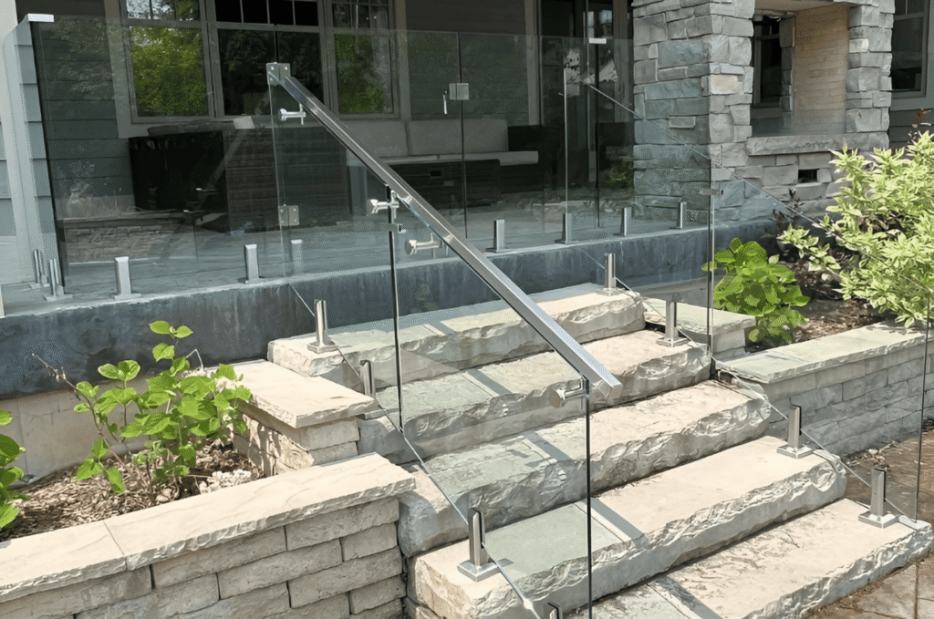 deck glass railing along natural stone steps with stainless posts, adding safety & clean modern look