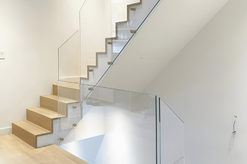 Modern house interior with light colored glass stair railing and floating steps, adding safety while keeping the space open.