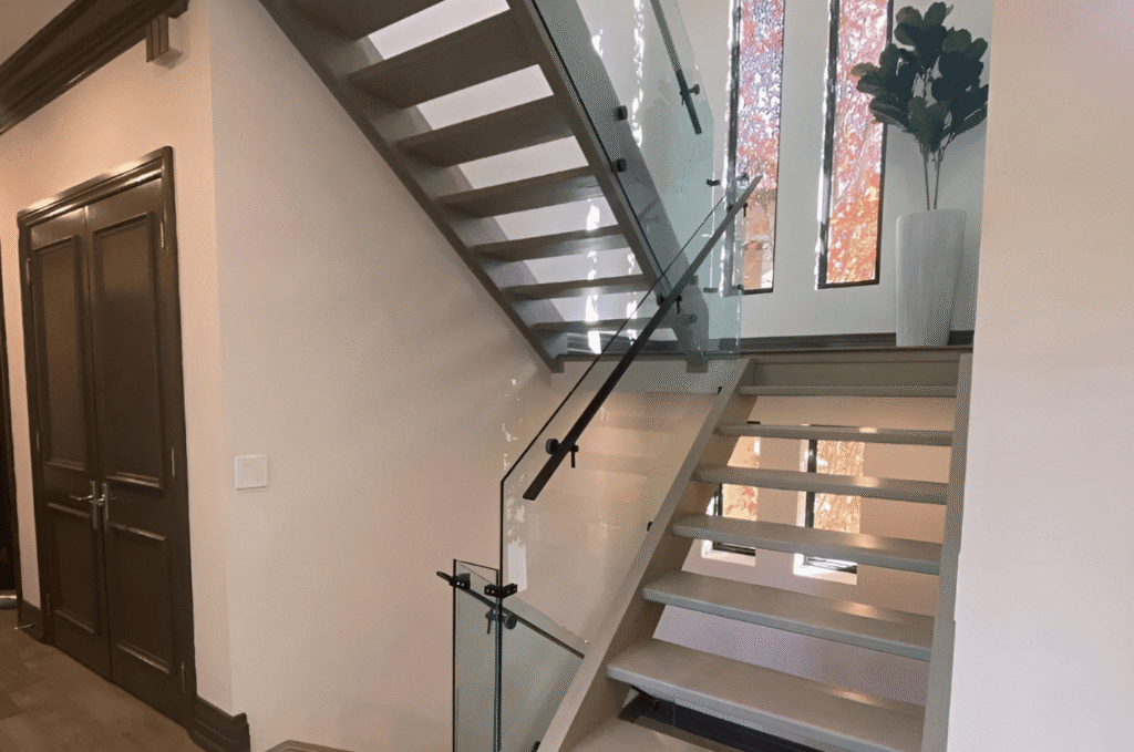 Interior staircase featuring glass railing systems with sleek hardware, adding safety and a modern design touch
