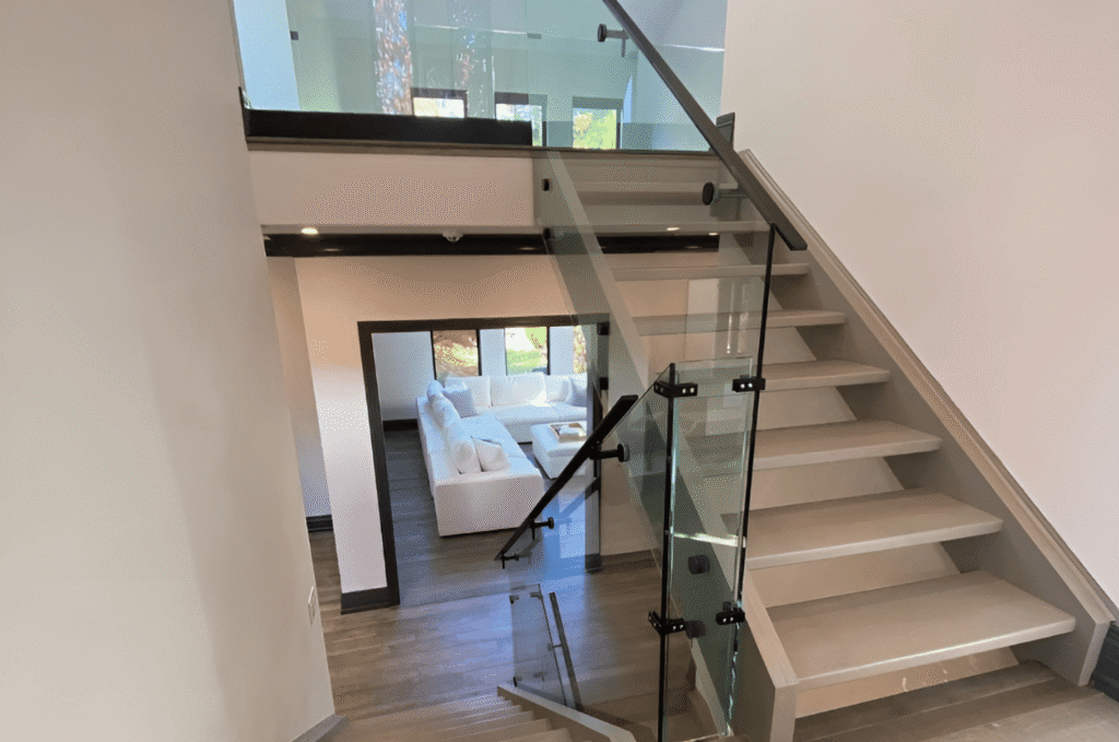 Multi-level staircase with premium glass railing systems, offering strong support while keeping the home bright and modern.