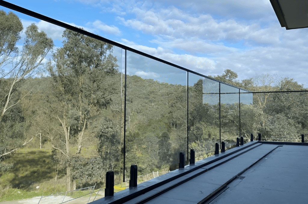 Outdoor balcony with clear outdoor glass railing that keeps the view open while providing safe edge protection.