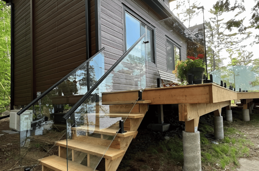 Wood deck with stairs and a clear outdoor glass railing that keeps beautiful waterfront views open
