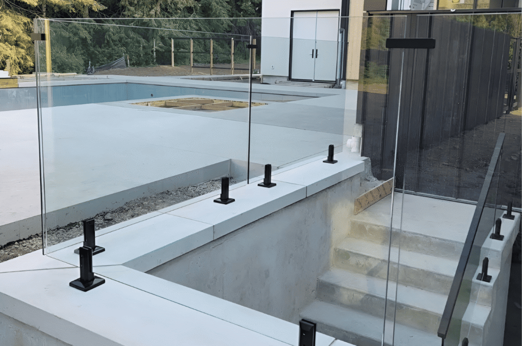 Outdoor glass railing installation with durable glass railing hardware mounted along steps