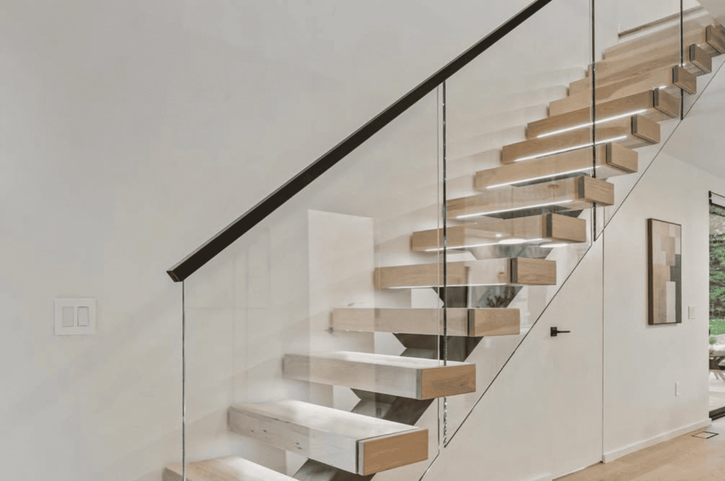 Floating wood stairs paired with a framed glass railing, creating a bright, open feel while keeping the staircase secure