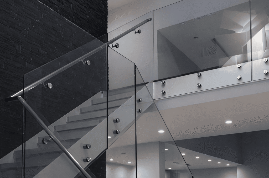 Modern staircase with stainless steel glass railing hardware, providing strong support and a clean, contemporary look