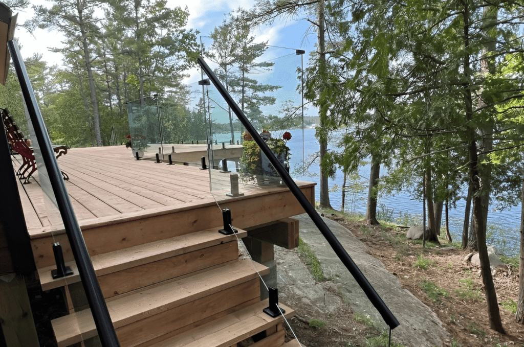 Contractor measuring deck corners for a glass railing quote before custom panels are made for a Seattle home railing project 