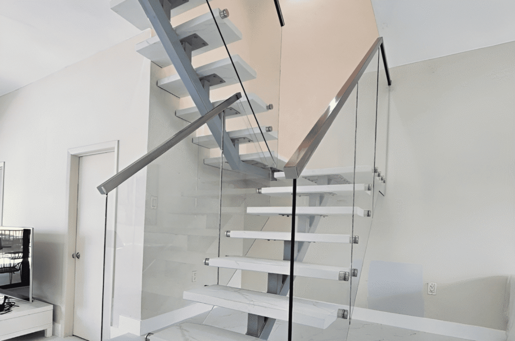 Frameless glass stair railing with standoff hardware on floating treads needing protection during interior renovation work