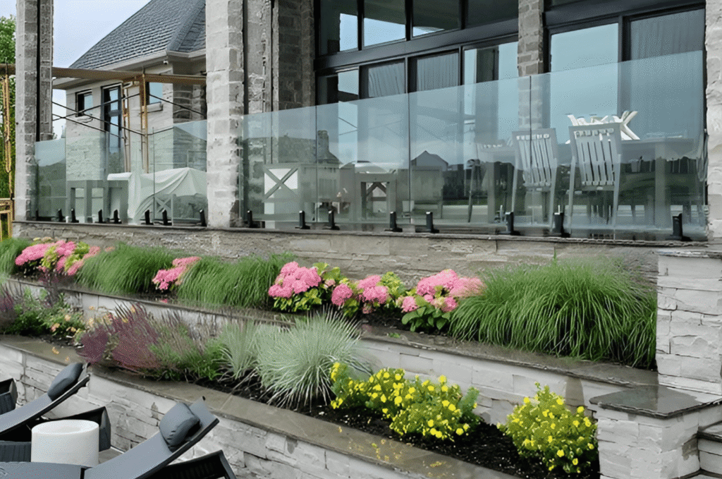 Exterior glass railing system on a stone patio with lush landscaping, built for the wet Seattle and Pacific Northwest climate